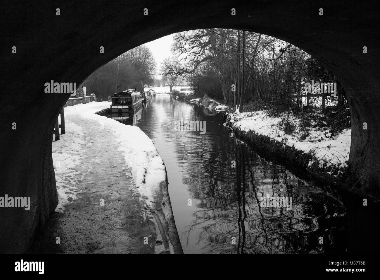 Narrowboats incorniciata da un ponte si vedono ormeggiati in Llangollen Canal nel tardo inverno Foto Stock
