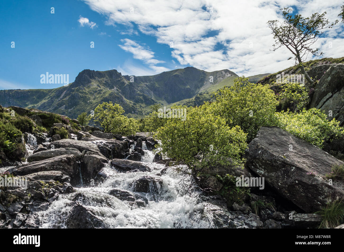 Da Llyn Idwal una cascata corre giù per il pendio della montagna a Cwm Idwal situato nel Nant Ffrancon Valley. Foto Stock