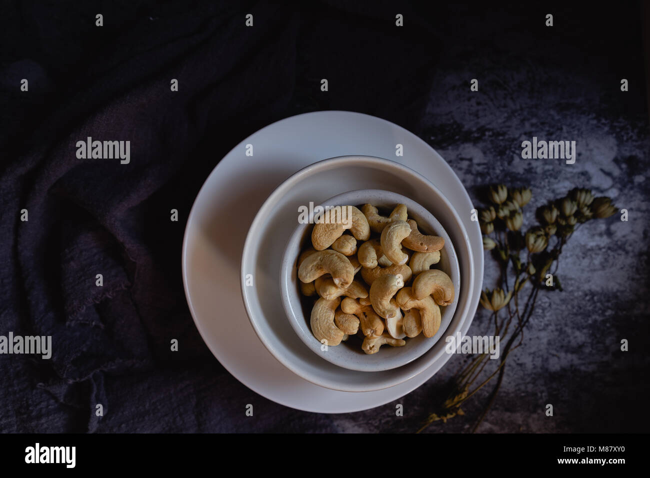 Noci di anacardio in ciotole. Sfondo scuro/ Foto Stock