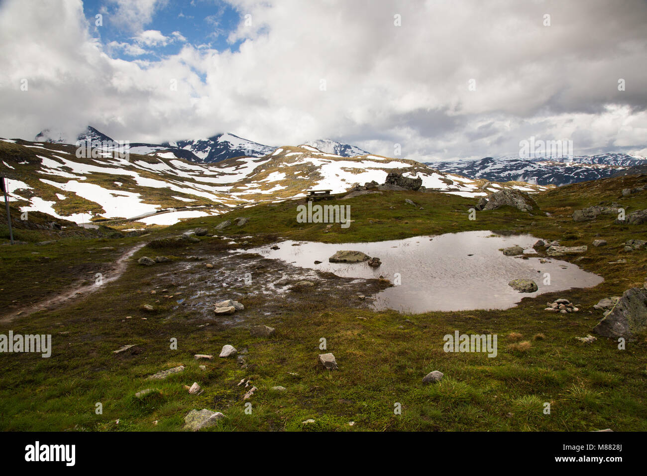 Ampia vista panoramica sulle montagne ricoperte di neve con un laghetto in primo piano Foto Stock