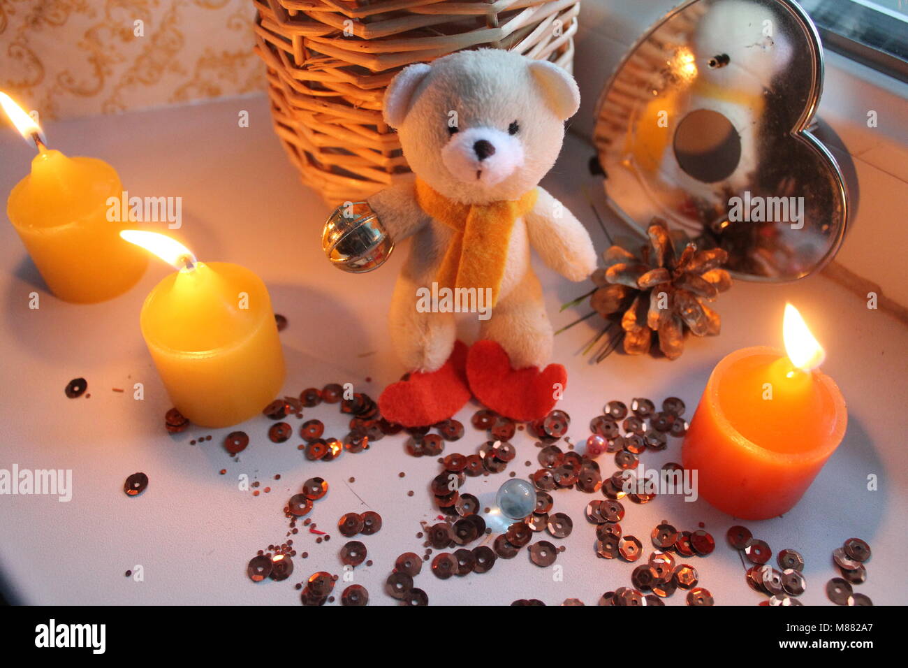 Bianco terry piccolo orsacchiotto con tre masterizzare di colore giallo brillante candele decorazione in vacanza Foto Stock