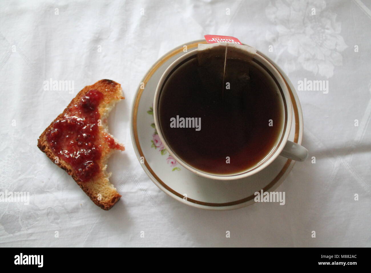 Tazza nera con tè dolce e di pace di grano tostato sotto la marmellata di frutti di bosco Foto Stock