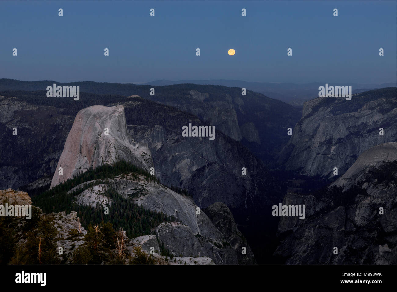 CA02874-00...CALIFORNIA - Impostazione della luna come il sole sorge con una vista di Half Dome e la valle di Yosemite da nuvole riposo nel Parco Nazionale di Yosemite. Foto Stock