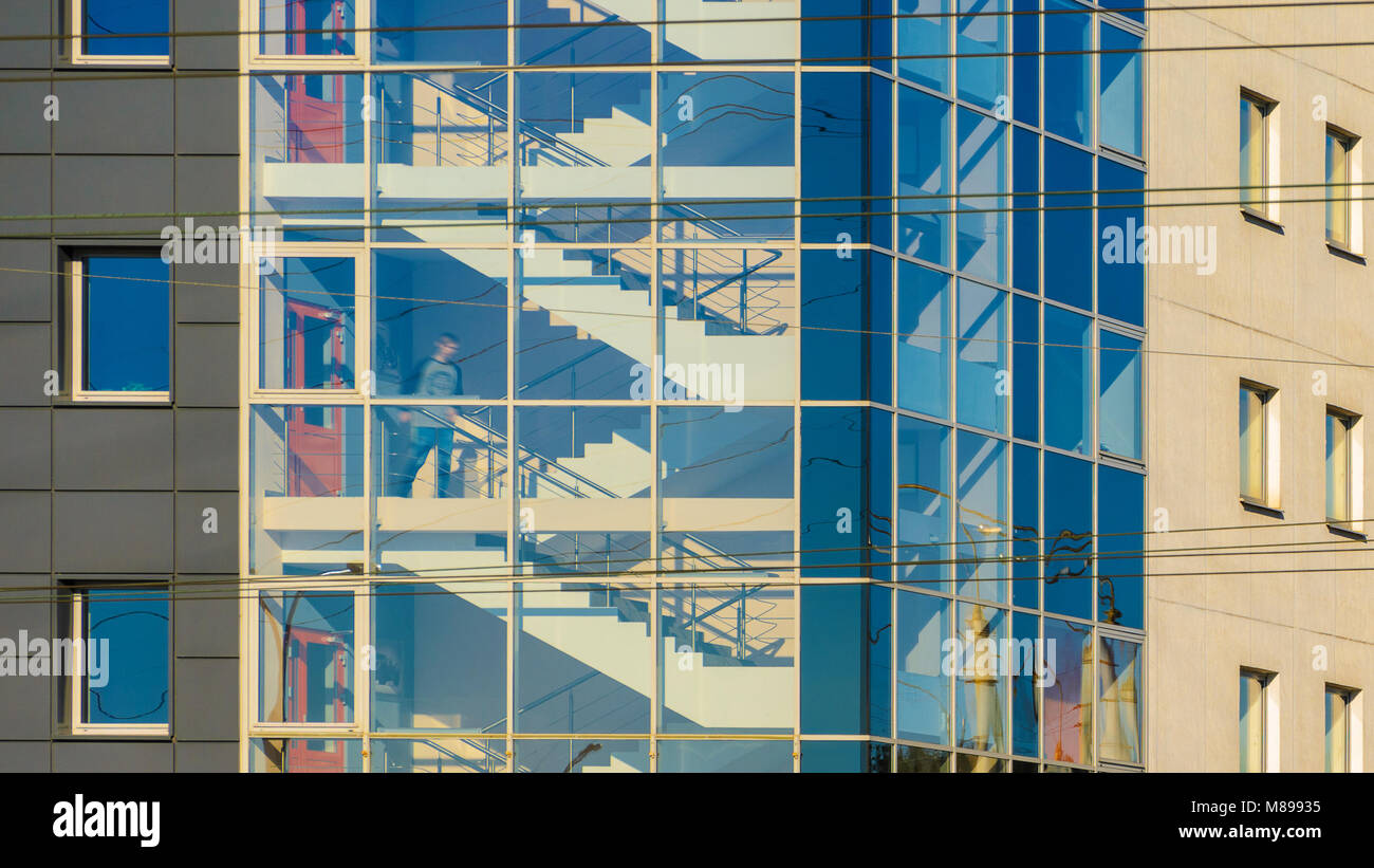 La figura di un uomo nella tromba delle scale di un edificio per ... Scale di vetro