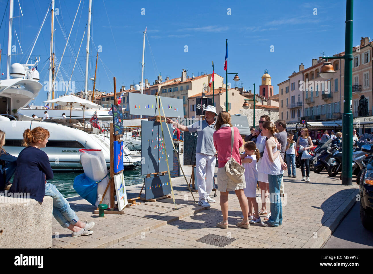 Pittore mostra i suoi dipinti a passeggiare lungomare al porto di Saint-Tropez, riviera francese, il sud della Francia, Cote d'Azur, in Francia, in Europa Foto Stock