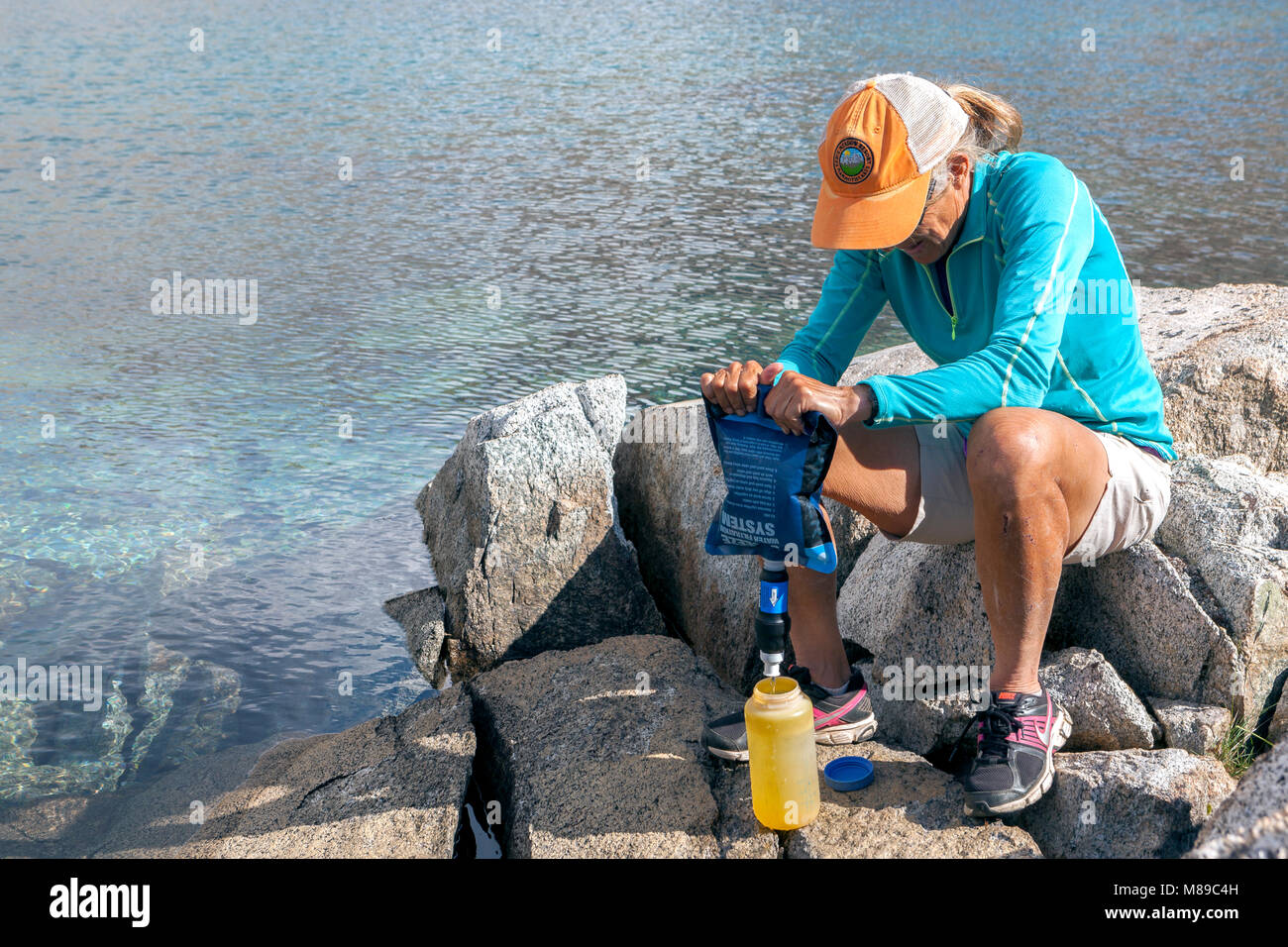 CA03317-00...CALIFORNIA - Vicky molla filtrare acqua usando un sacchetto di spremere al Lago di Marjorie in Kings Canyon National Park. (MR#S1) Foto Stock
