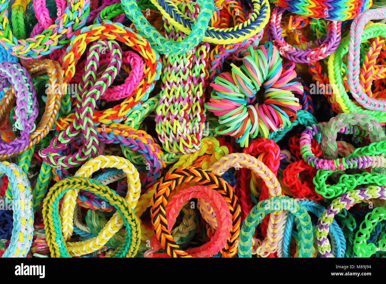 Sfondo - vari tipi di braccialetti colorati, intrecciato in gomma Foto Stock
