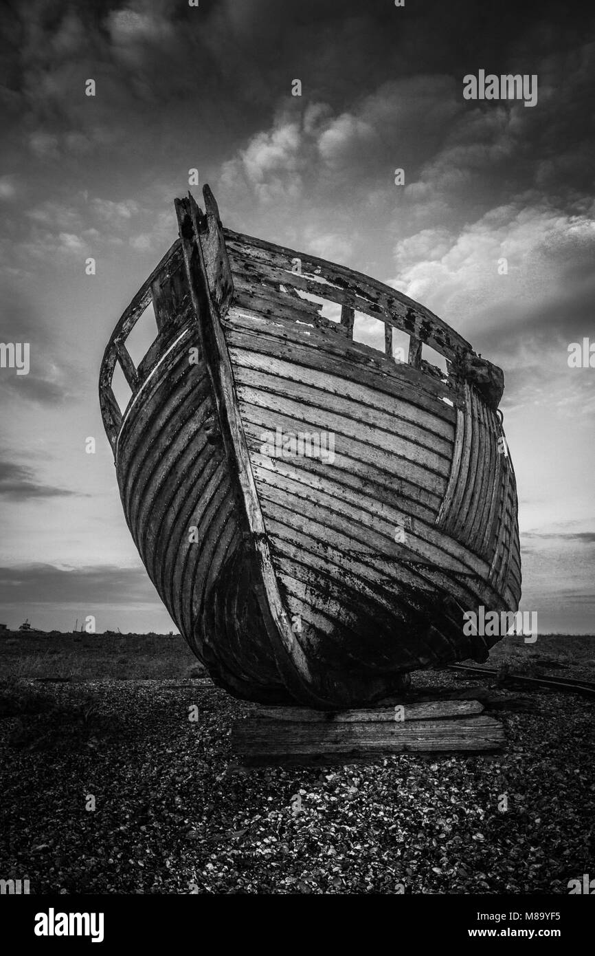 Barca a sinistra a decadimento sulla spiaggia di Dungeness, Kent, Regno Unito Foto Stock