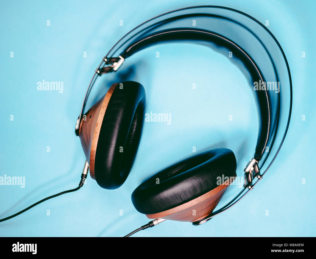 Legno nero cuffie audio per ascoltare isolato su sfondo blu Foto Stock