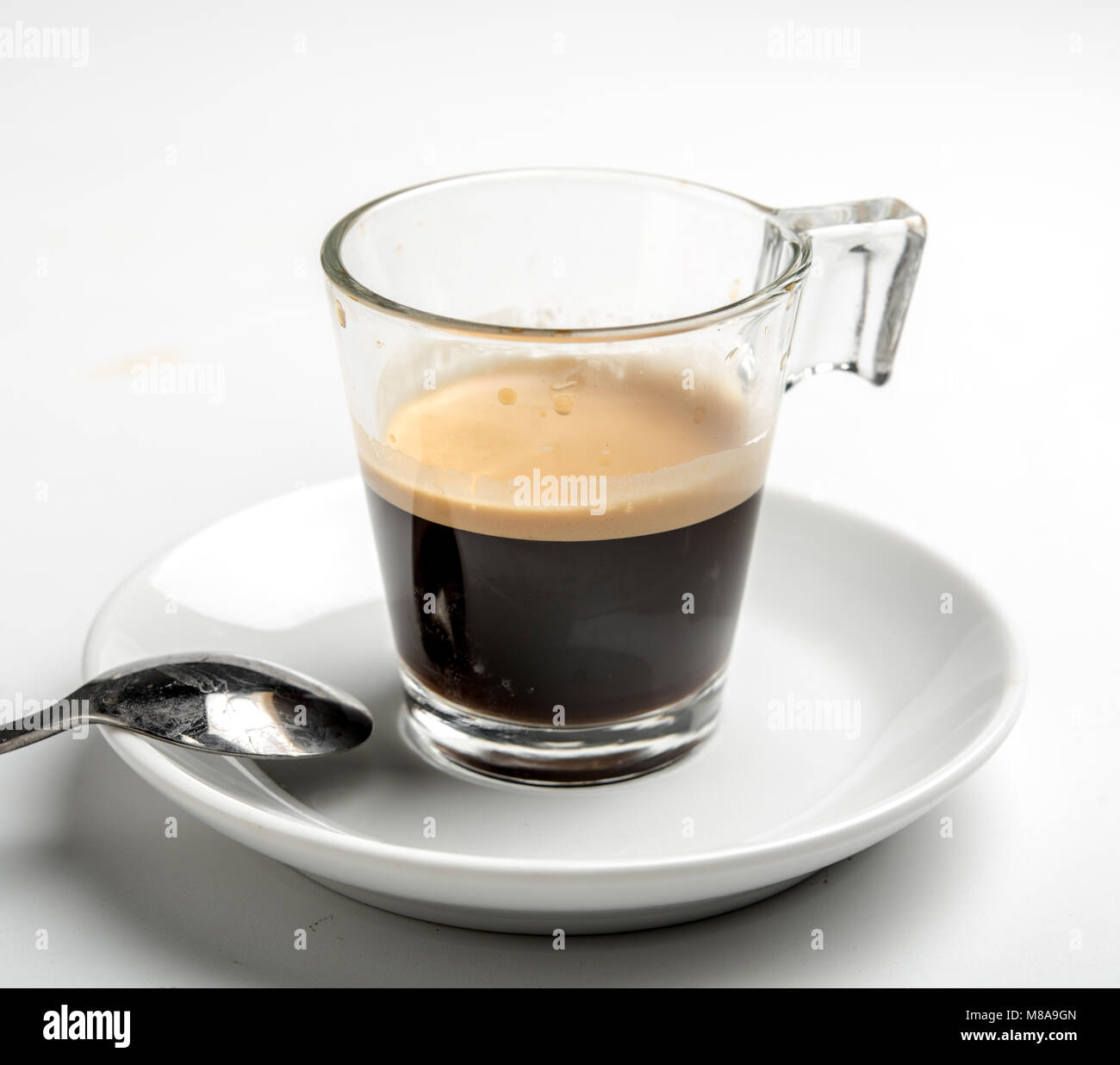Un bicchiere di espresso su sfondo bianco Foto Stock