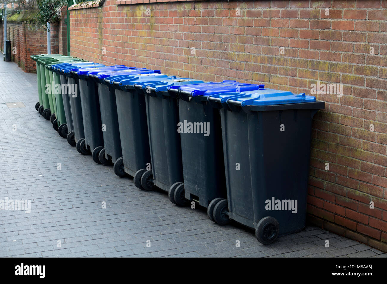 Una fila di rifiuti domestici bidoni in una Street, Stratford-upon-Avon, Regno Unito Foto Stock