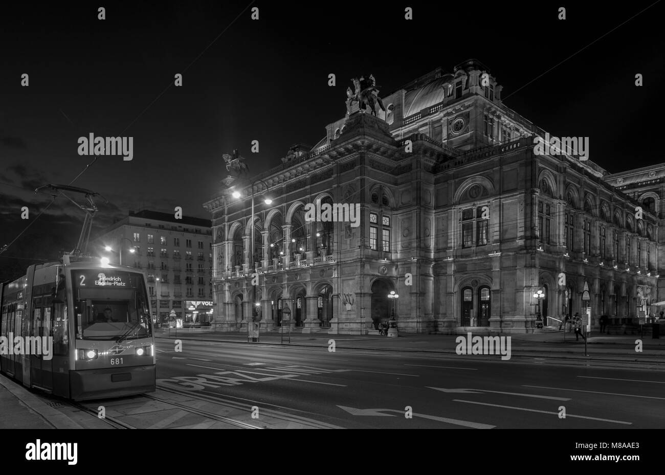 Ripresa a tutto campo del traffico che passa di fronte all'Opera di Vienna Casa su Opernring. Preso inizio serata nel mese di settembre come le luci della città sono in arrivo su Foto Stock