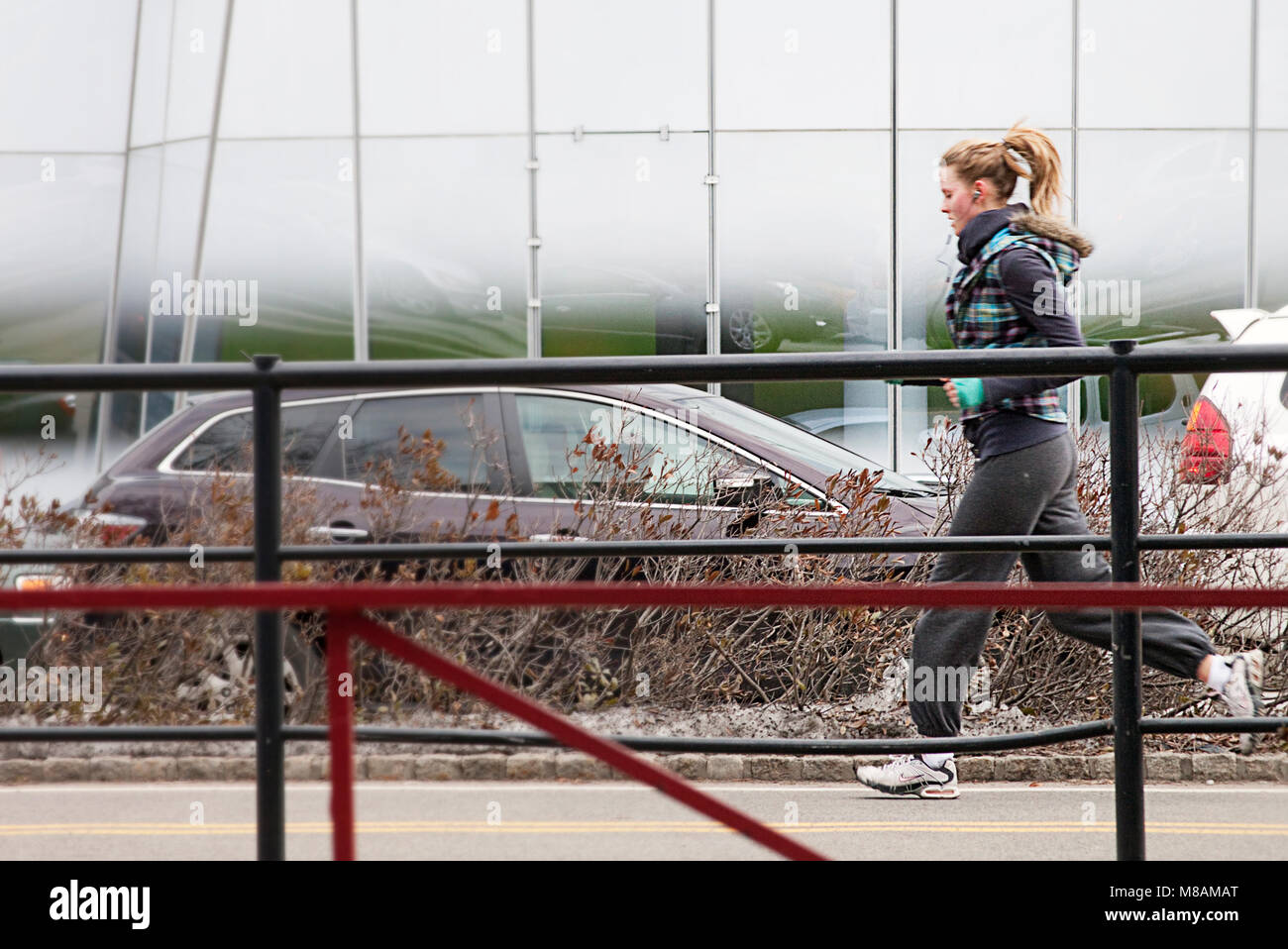 Una giovane donna in esecuzione il jogging all'aperto nella città di New York durante l'inverno. Uno stile di vita sano Foto Stock