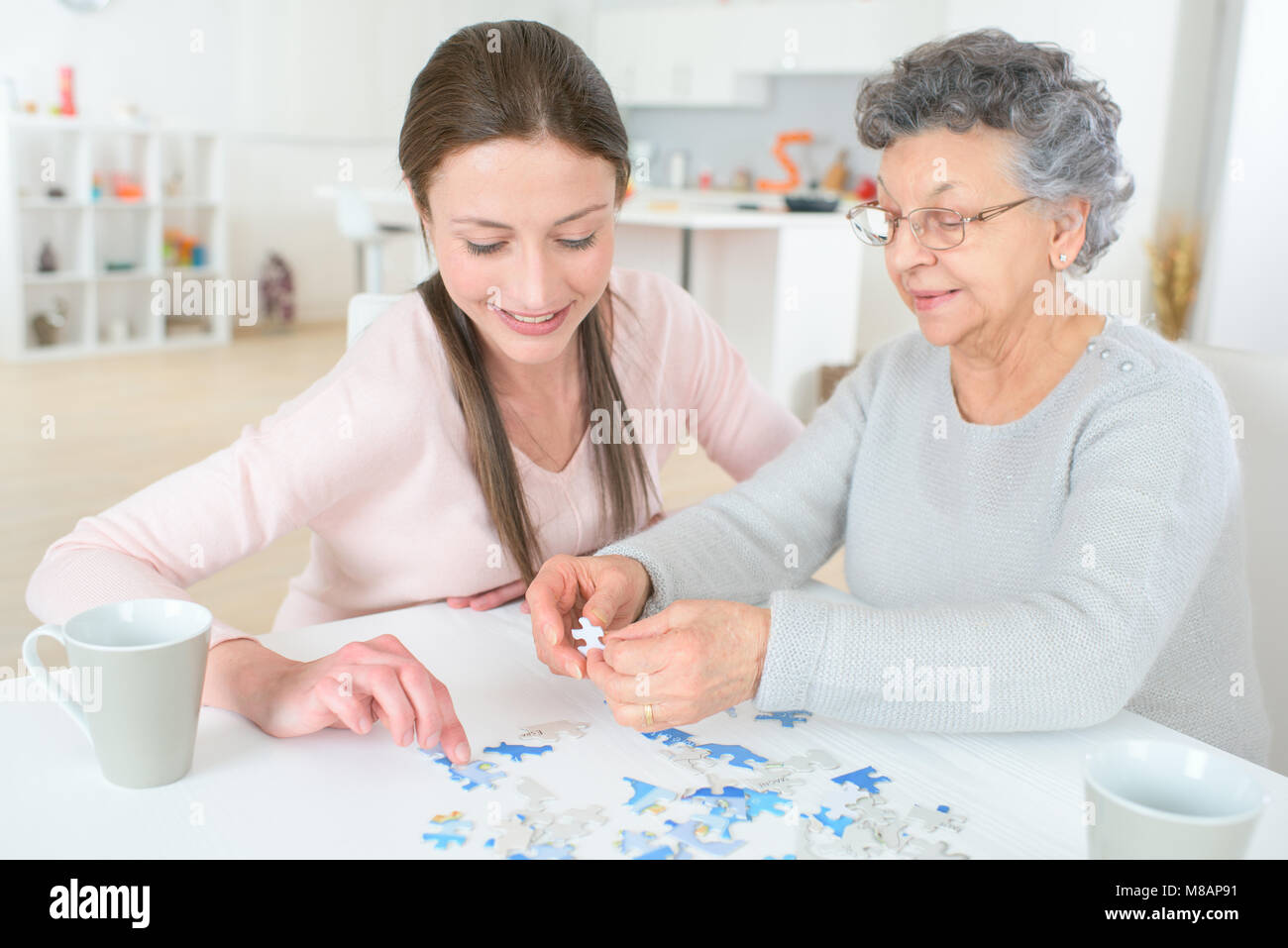 Nipote di risolvere puzzle con l'aiuto di sua nonna Foto Stock
