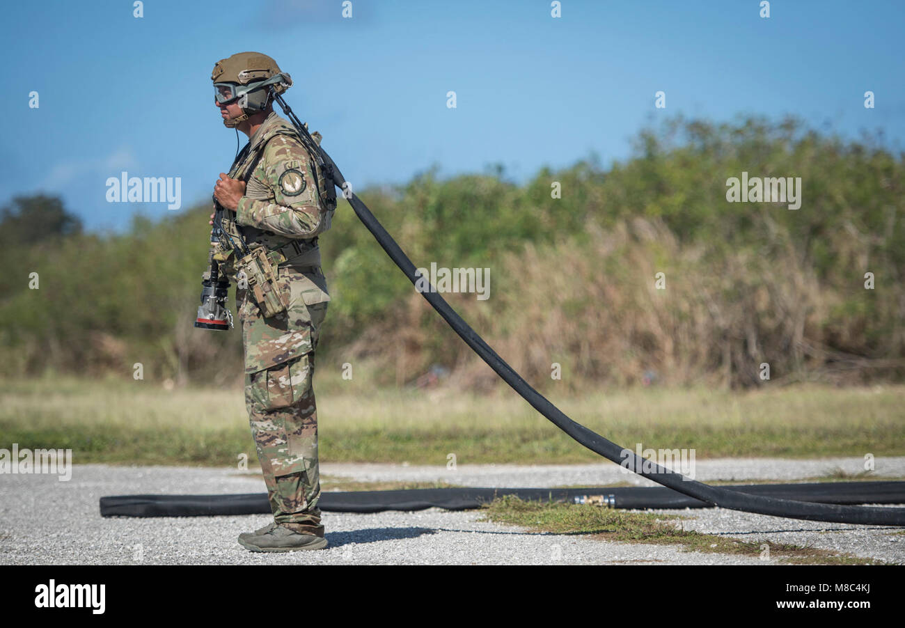 Un aviatore assegnato alla XXXVI Mobilità squadrone di risposta attende il segnale di agganciare un elicottero conveniente sistema di rifornimento carburante (lei) ad una C-130J Super Hercules, assegnato alla XXXVI Airlift Squadron, durante l'esercizio a far fronte nord 2018 a Tinian, U.S. Repubblica della Mariana Islands settentrionale, Feb. 26. La sua è una distribuibile del sistema di alimentazione del carburante in grado di memorizzare 3.000 galloni di carburante. (U.S. Air Force Foto Stock