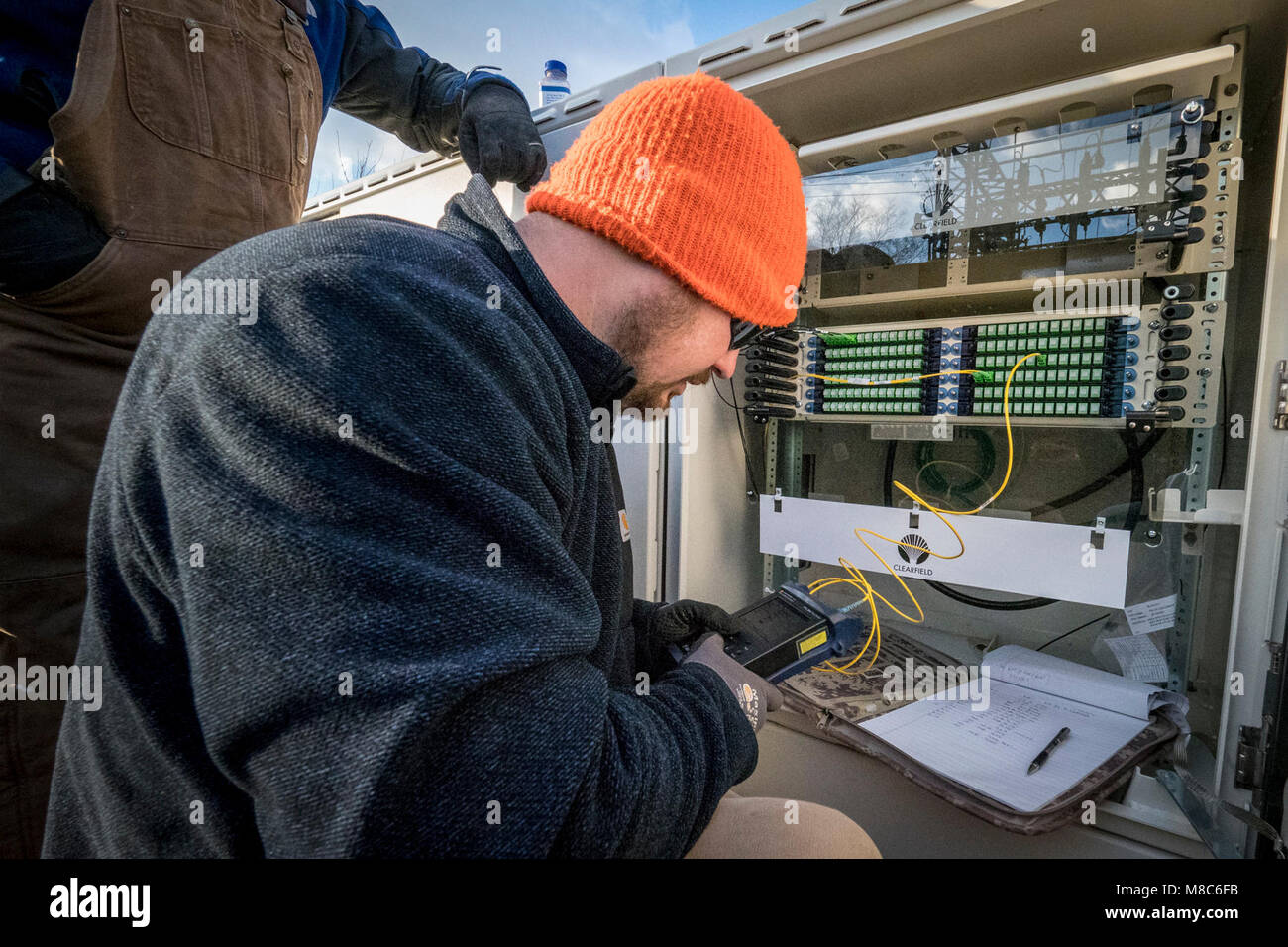 Contratto a fibra ottica tecnico Nathan Roten esegue il test di connessione in fibra a uno di Virginia BARC Cooperativa ELETTRICA SOTTOSTAZIONI pannelli patch. BARC è leader di mercato in Lexington, Virginia area installazione di cavi a fibre ottiche per l'esistente rete elettrica, che porterà affidabili a banda larga ad alta velocità per la zona per la prima volta. Nelle aree rurali dove affari e residenziale i consumatori utilizzano il servizio a banda larga sono più suscettibili di godere di redditi più alti, abbassare i tassi di disoccupazione e una crescita più forte rispetto a quelli senza banda larga. Poiché offre a banda larga nelle aree rurali la connettività al business, educa Foto Stock