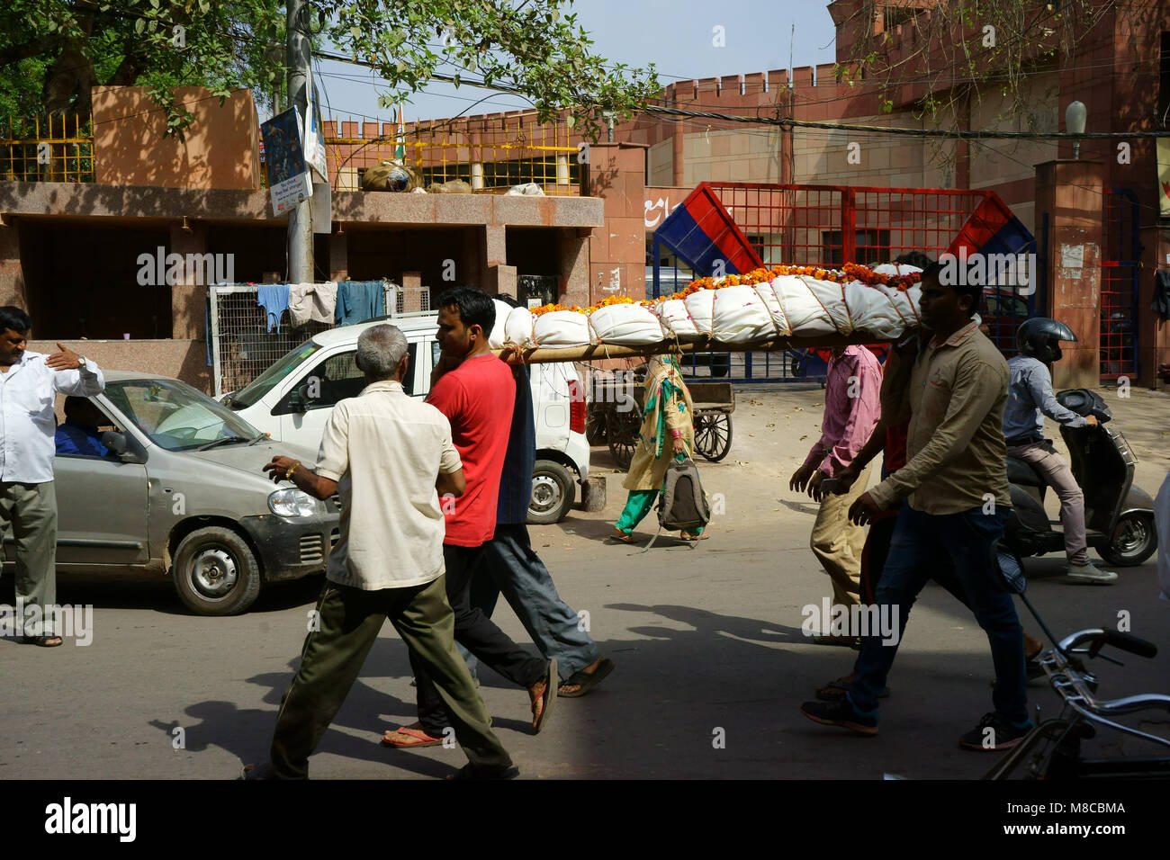 Gli uomini che trasportano il corpo morto avvolti in teli di lino attraverso la strada di Vecchia Delhi al funearal, India Foto Stock