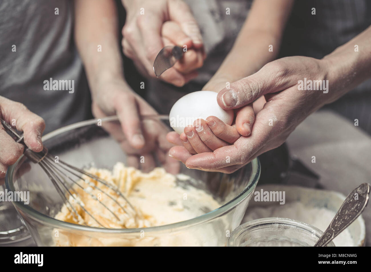 Le madri e i bambini con le mani in mano cuocere la pasta per biscotti fatti in casa. Abbiamo cuoco in cucina insieme con i bambini. Famiglia felice Foto Stock