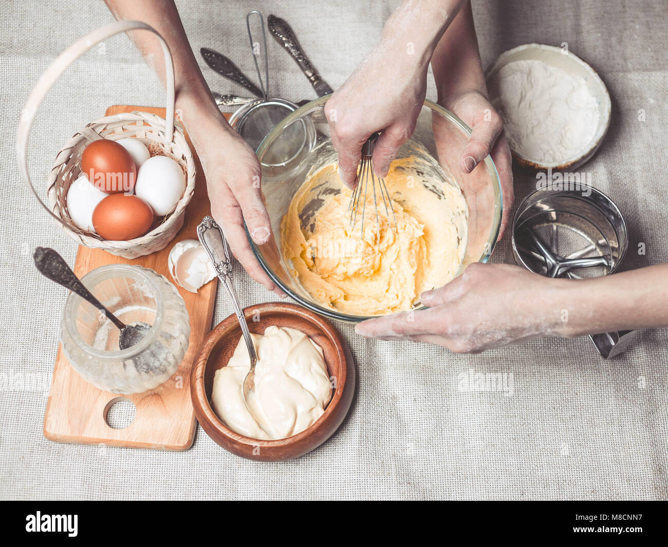 Le madri e i bambini con le mani in mano cuocere la pasta per biscotti fatti in casa. Abbiamo cuoco in cucina insieme con i bambini. Famiglia felice Foto Stock