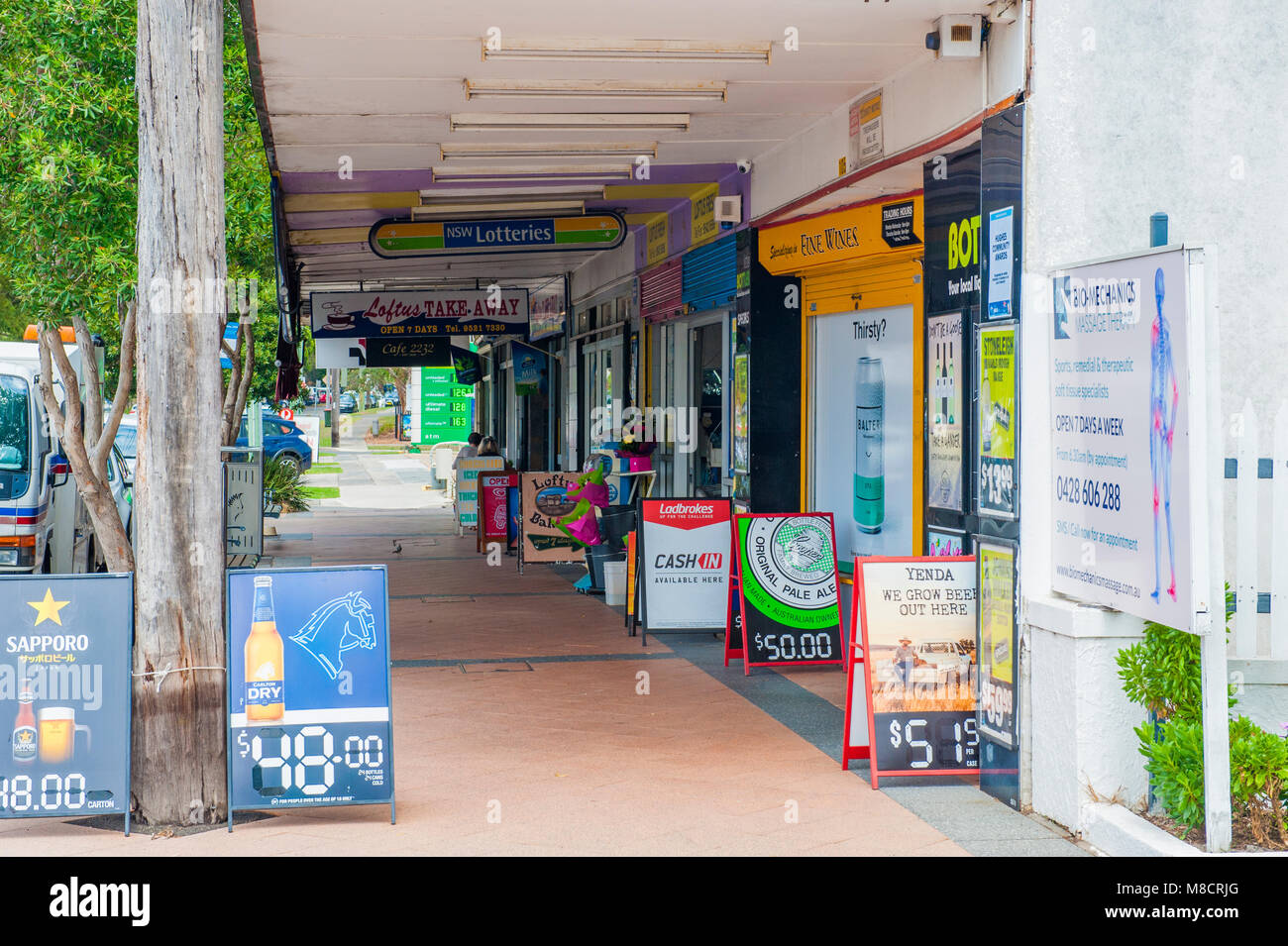 Suburban Loftus. Vista di negozi locali con gente seduta al café. LOFTUS. NSW. AUSTRALIA Foto Stock