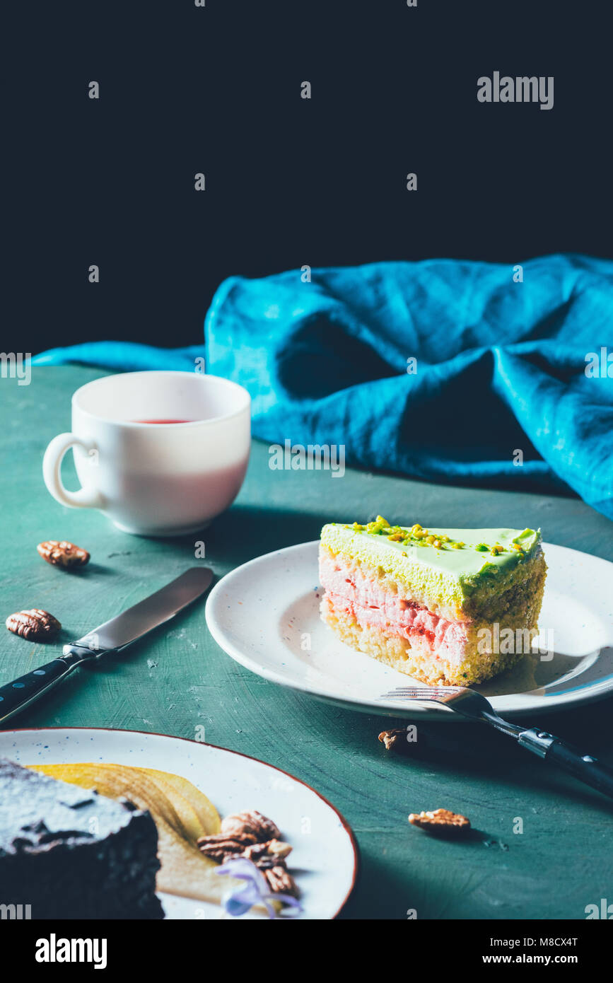 Vista ravvicinata del pezzo di torta sulla piastra e la tazza di tè Foto Stock