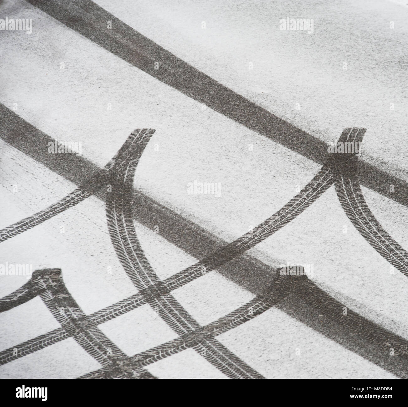 Skidmarks da una vettura in neve fresca su una strada Foto Stock