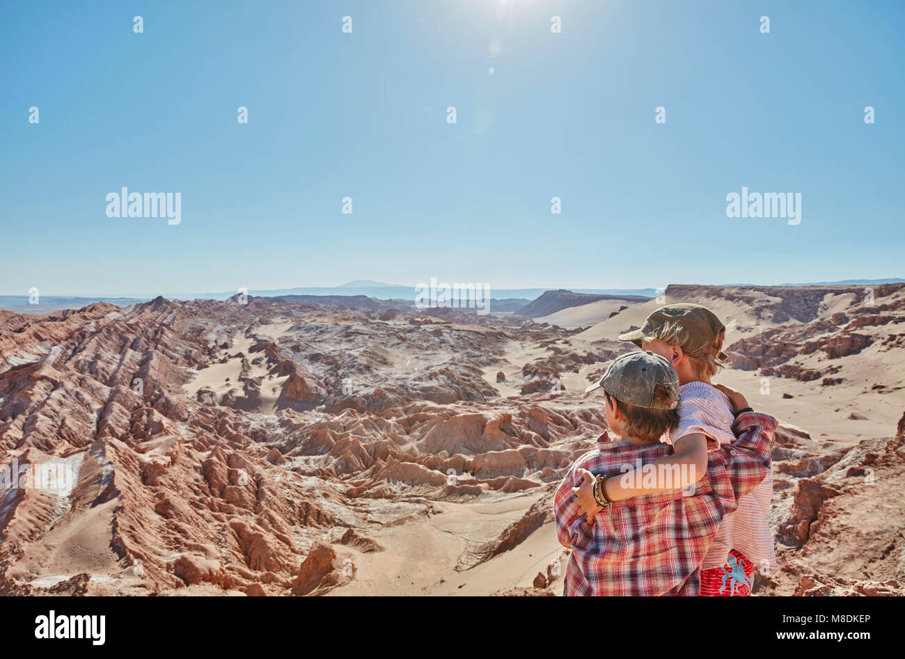 Ragazzo e suo fratello che guarda oltre il paesaggio del deserto di Atacama, Cile Foto Stock