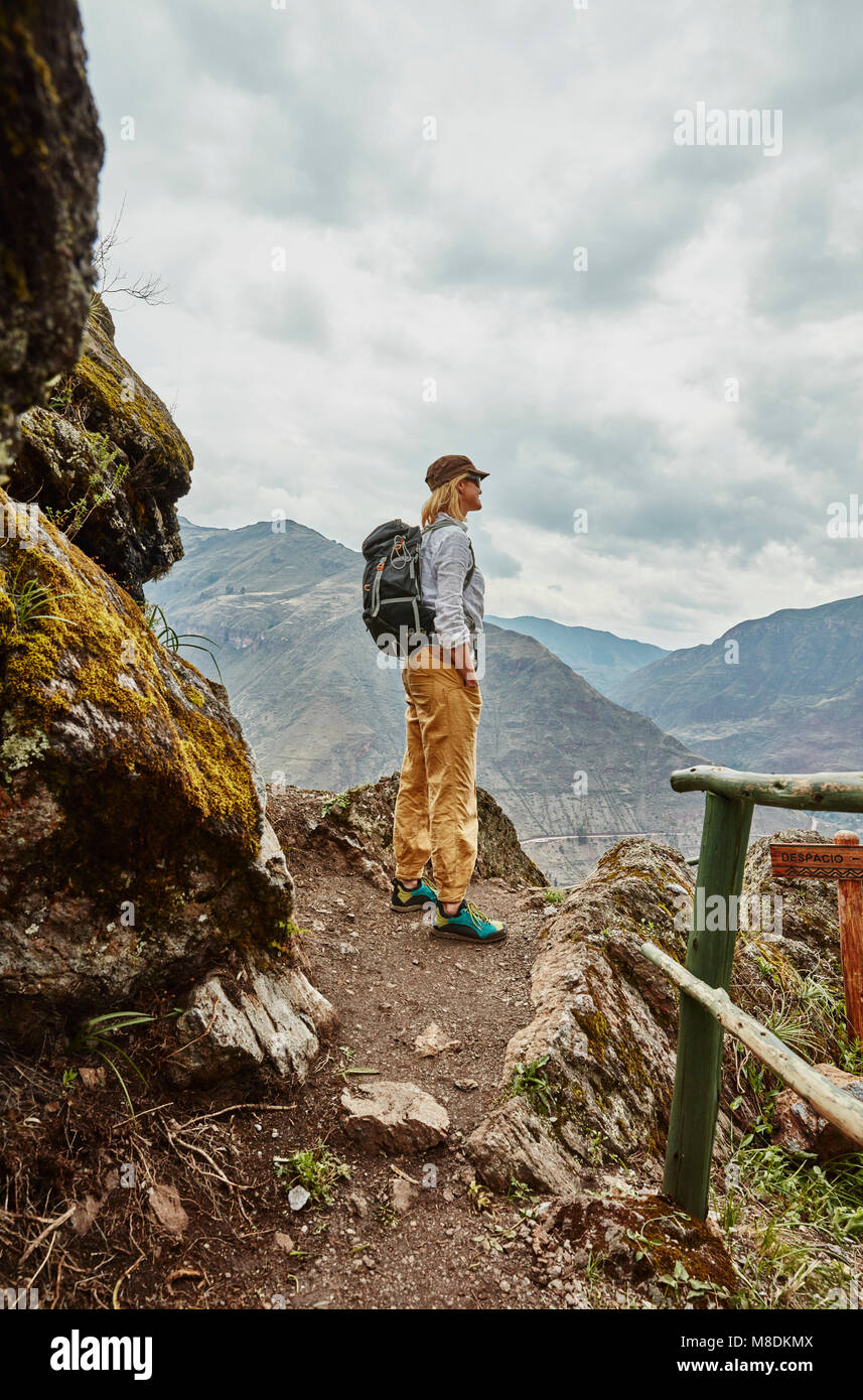 Escursionista femmina guardando a montagne distanti, Pisac, Cusco, Perù Foto Stock