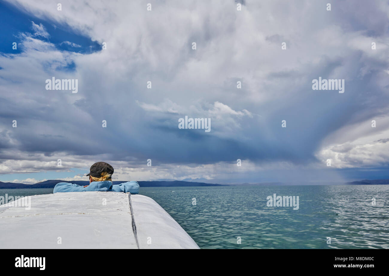 Donna sulla barca, guardando a vista, vista posteriore, Huarina, La Paz, Bolivia, Sud America Foto Stock