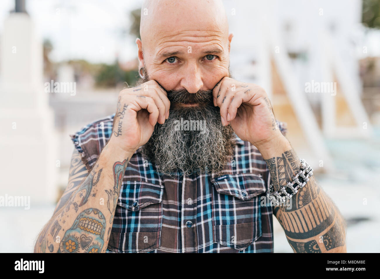 Ritratto di maschio maturo hipster tirando i suoi baffi Foto Stock