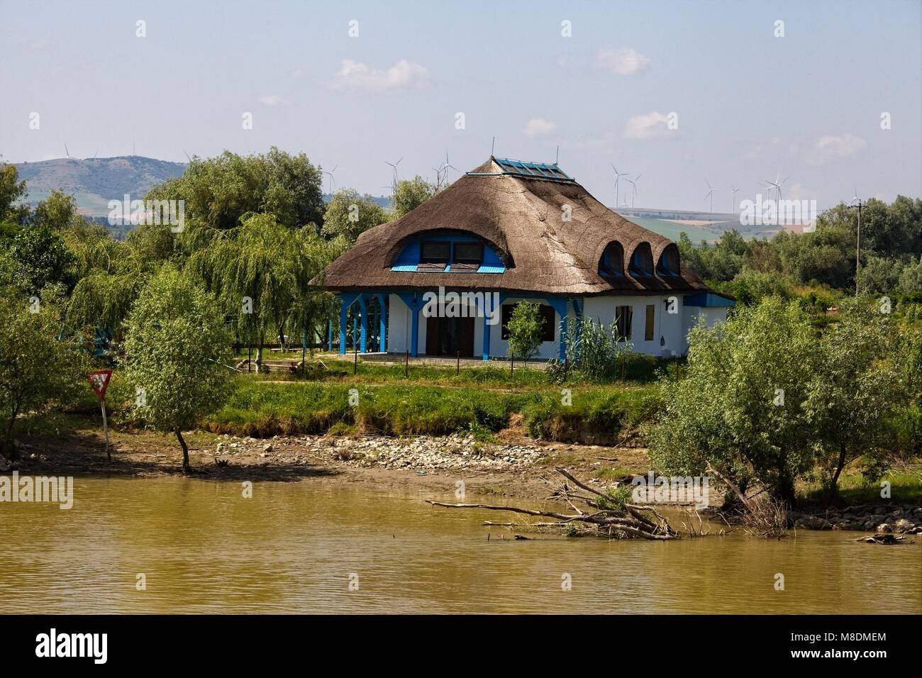 Le spalliere tetto di paglia e delle turbine a vento A VALLE DI TULCEA sul fiume Danubio DELTA Foto Stock