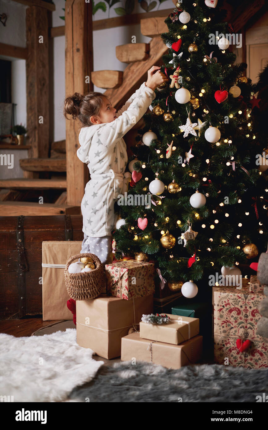 Ragazza giovane decorare albero di Natale Foto Stock