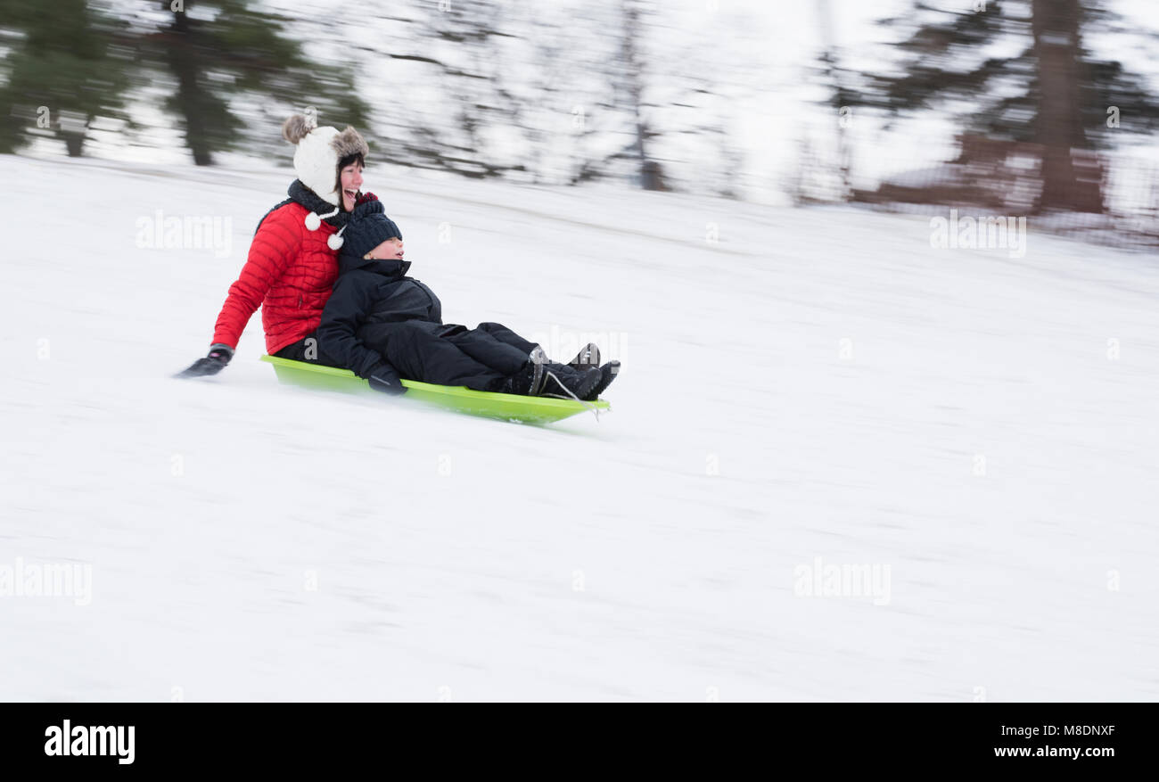 Madre e figlio slittino sulla neve hill Foto Stock