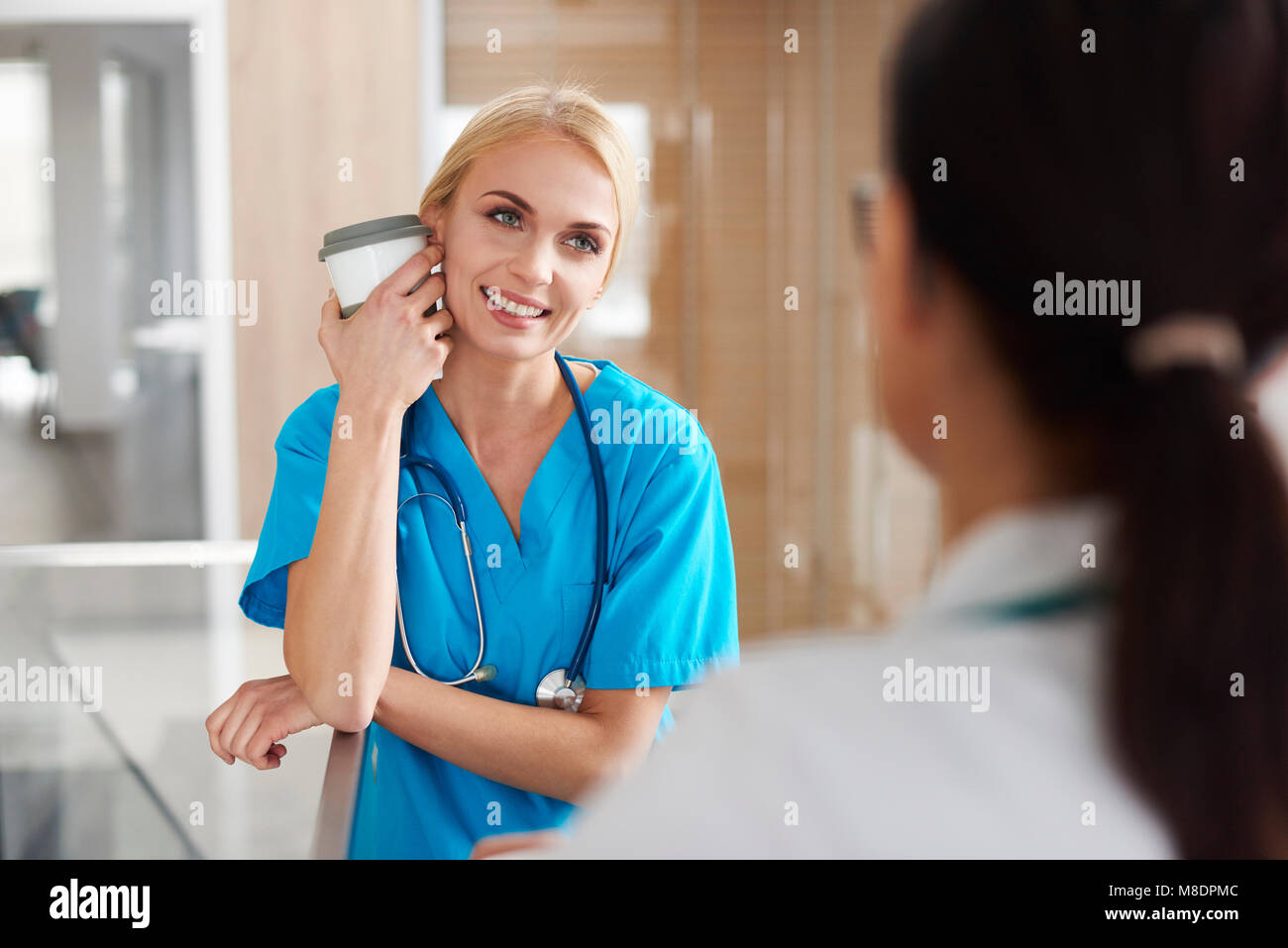 Medico e chirurgo a parlare in corridoio Foto Stock