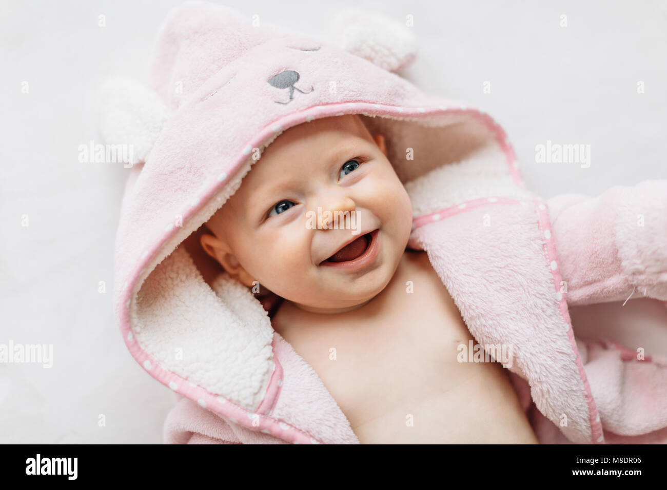 Ritratto di bambina in asciugamano con cappuccio che guarda lontano sorridente Foto Stock