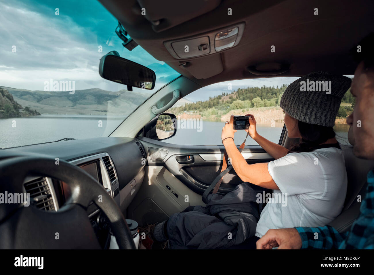 Matura in auto, giovane donna prendendo fotografia attraverso la finestra auto, Silverthorne, Colorado, STATI UNITI D'AMERICA Foto Stock