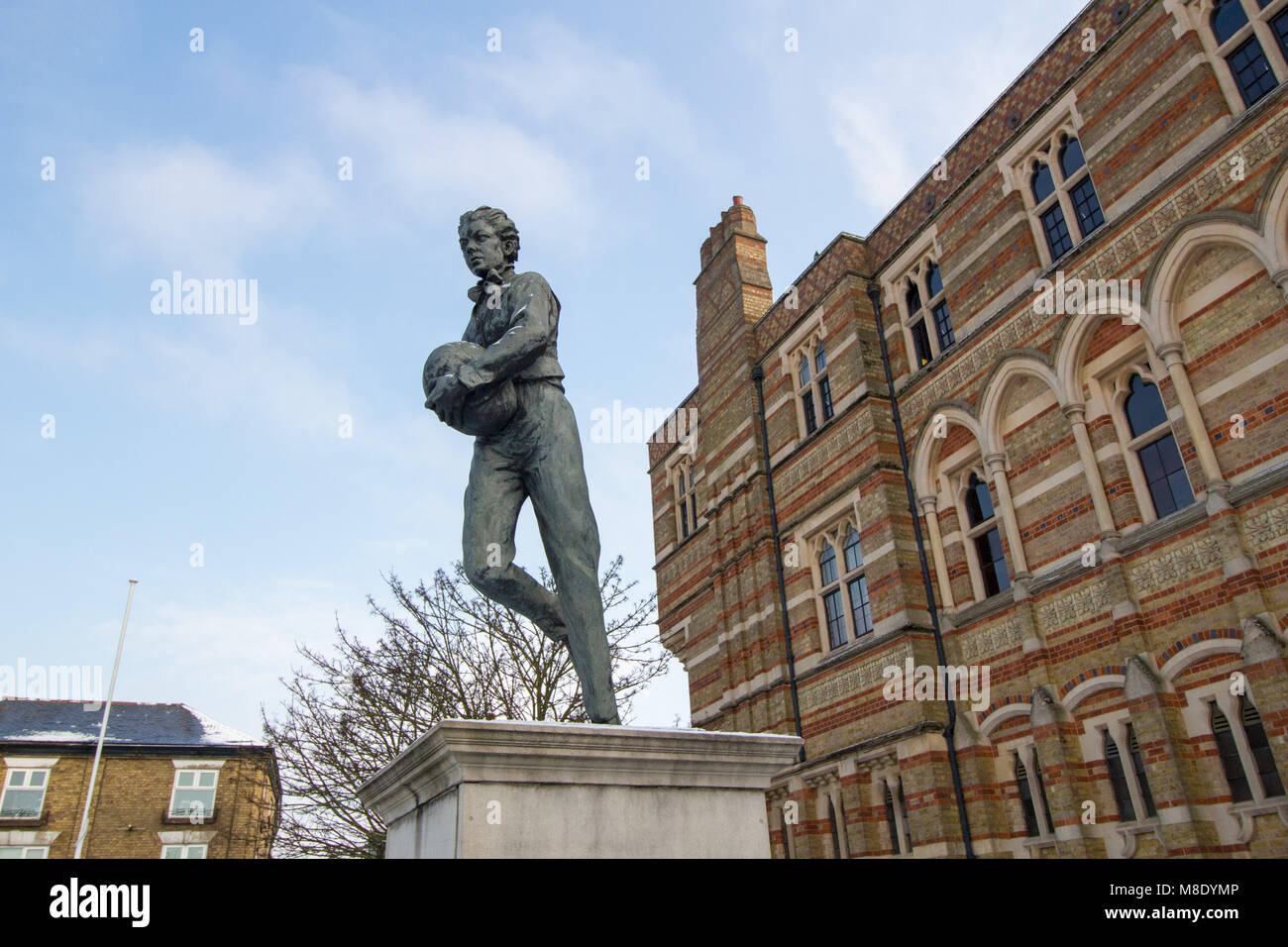 La statua di un giovane William Webb Ellis chi ha inventato il Rugby al di fuori della scuola di Rugby nel centro della cittadina di Rugby. Foto Stock