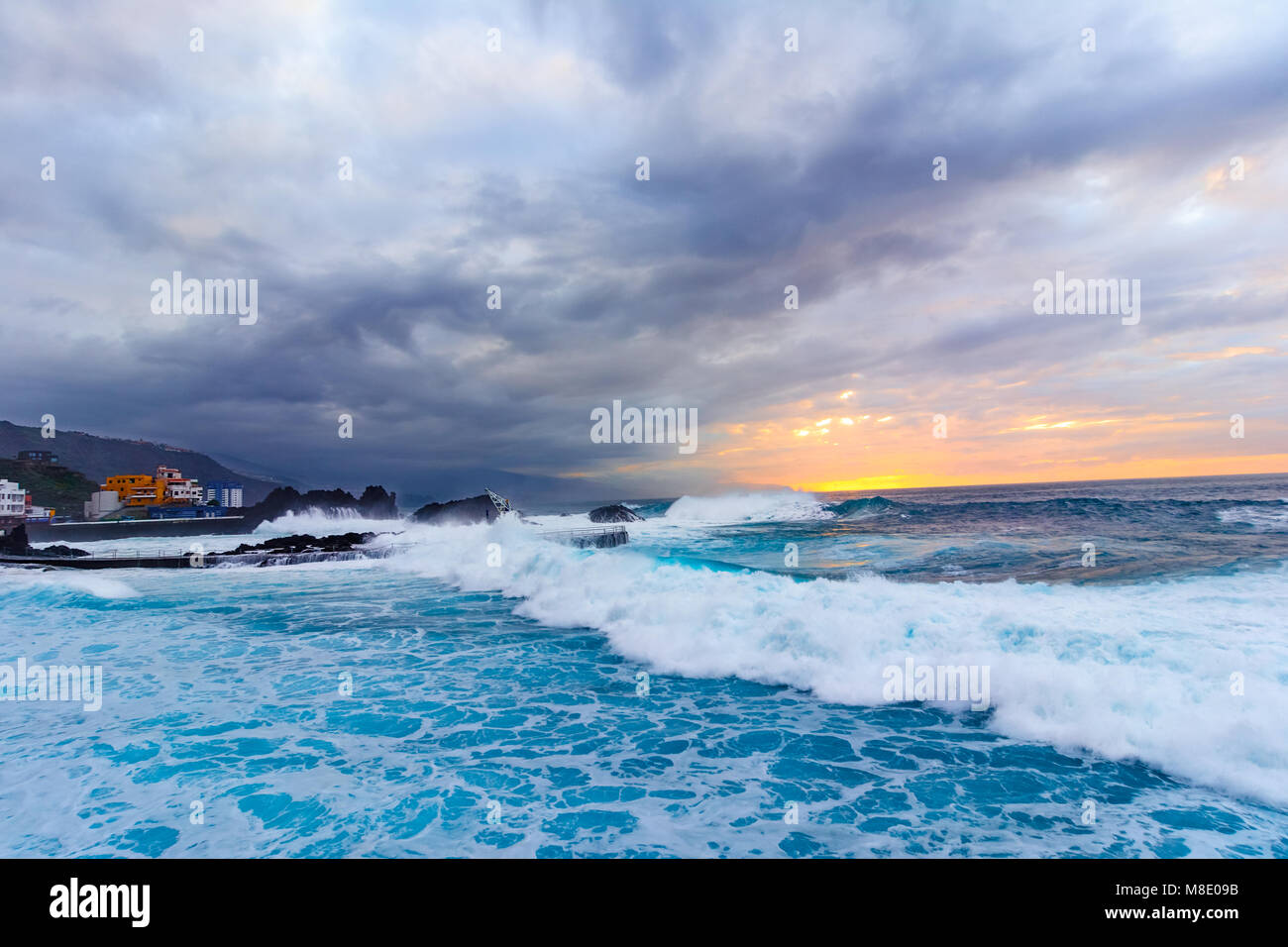 Tenerife, Isole canarie, Spagna: il sole tramontare sull'Oceano Atlantico su un maltempo Foto Stock
