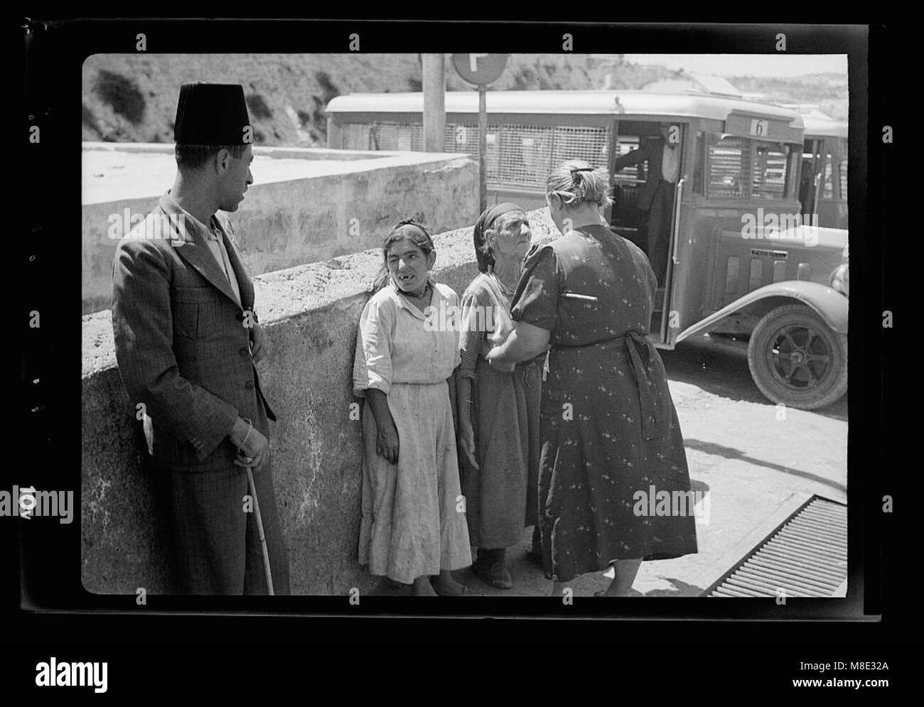 Fotografia che raffigura una poliziotta russa alla ricerca di armi presso la porta di Giaffa di una donna ebrea. Questa immagine riflette l'atmosfera tesa e le misure del governo in risposta ad atti terroristici, catturando un momento di protocollo di sicurezza durante un periodo difficile della storia. Foto Stock