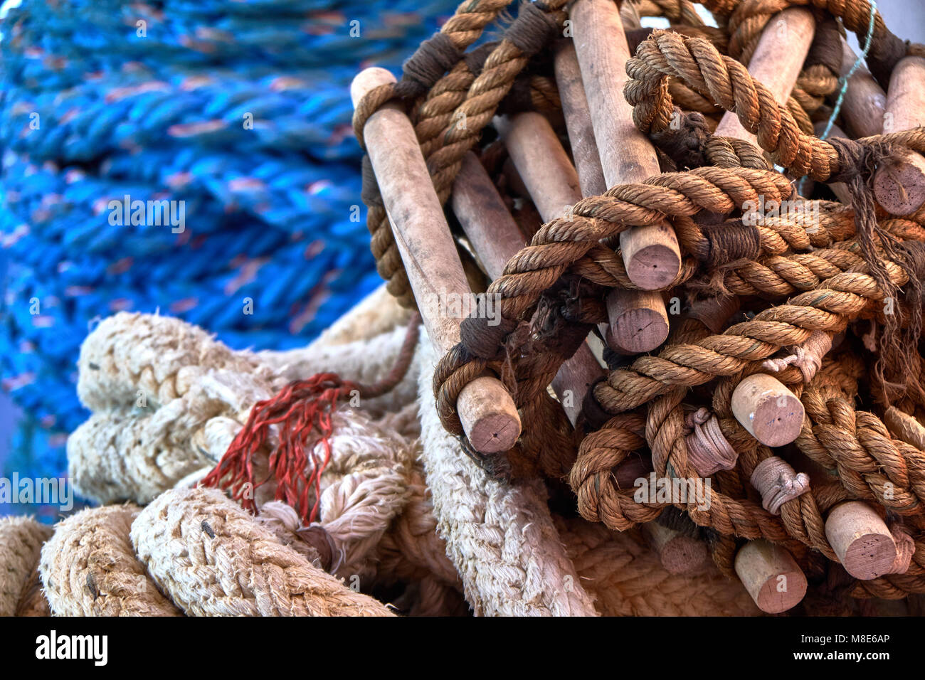 La scala a fune e le funi multicolore si trovano attorcigliate sul ponte blu di una vista da primo piano del traghetto passeggeri Foto Stock