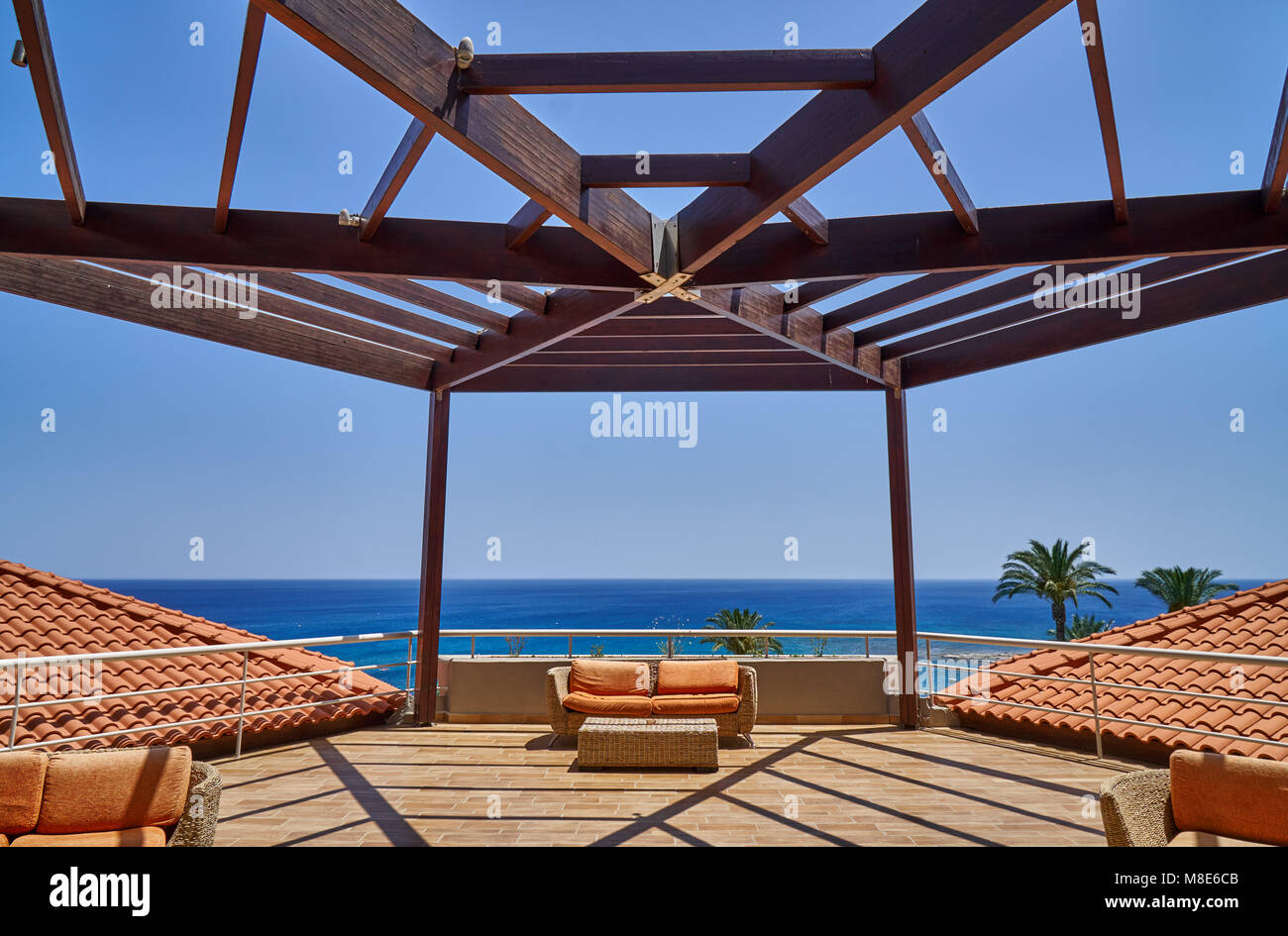 Lussuosa terrazza con pergolato e divani arancioni Foto Stock
