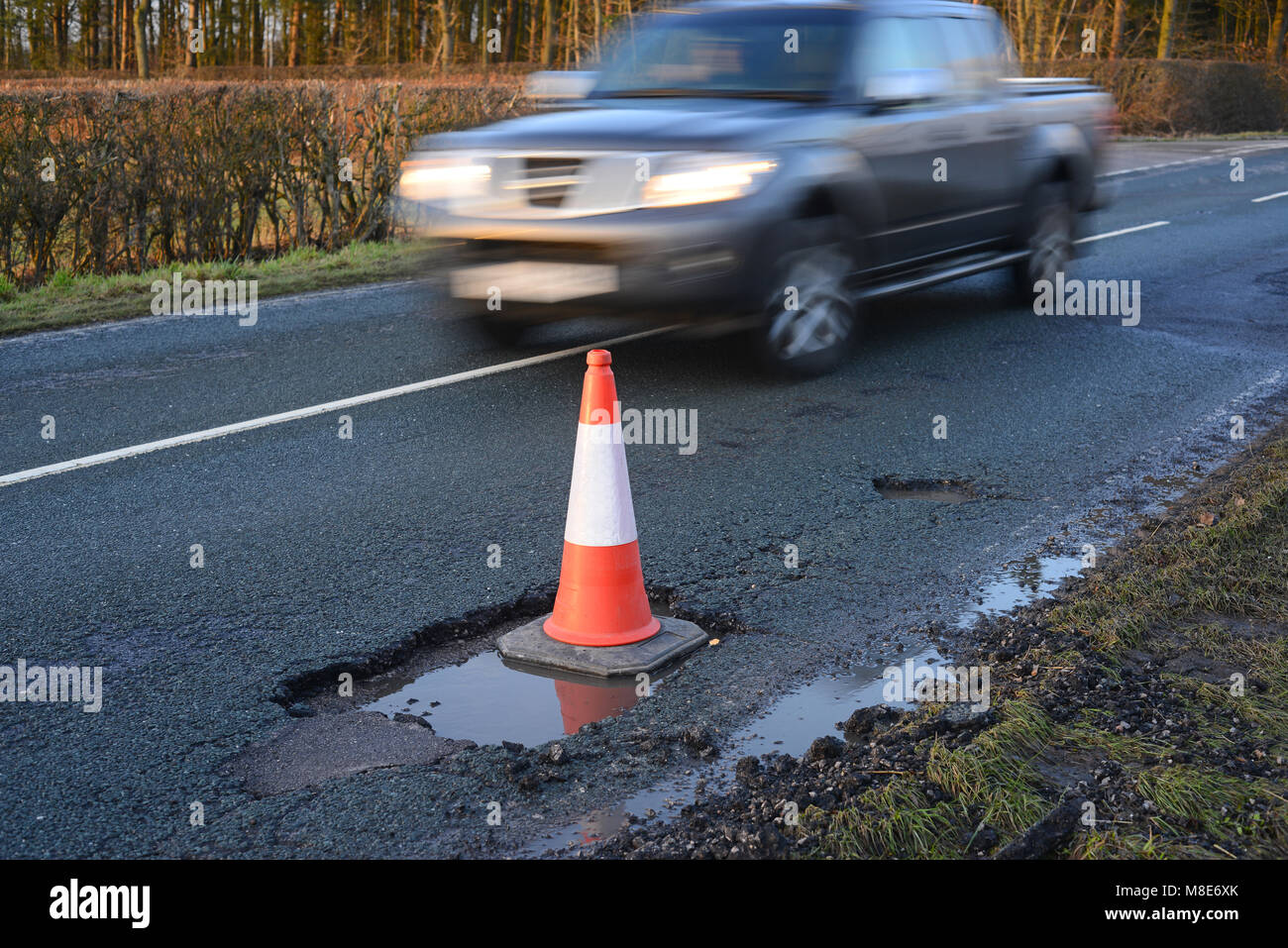 Il traffico che passa gran cono gigante di marcatura buche sulla strada di campagna dello Yorkshire York Regno Unito Foto Stock