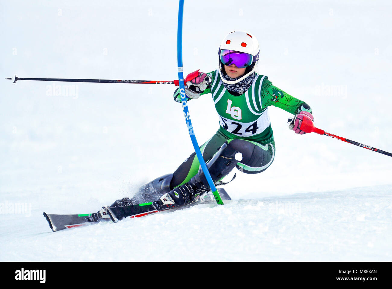 Un sciatore alpino in corrispondenza di un cancello sul corso di slalom durante una gara. Foto Stock