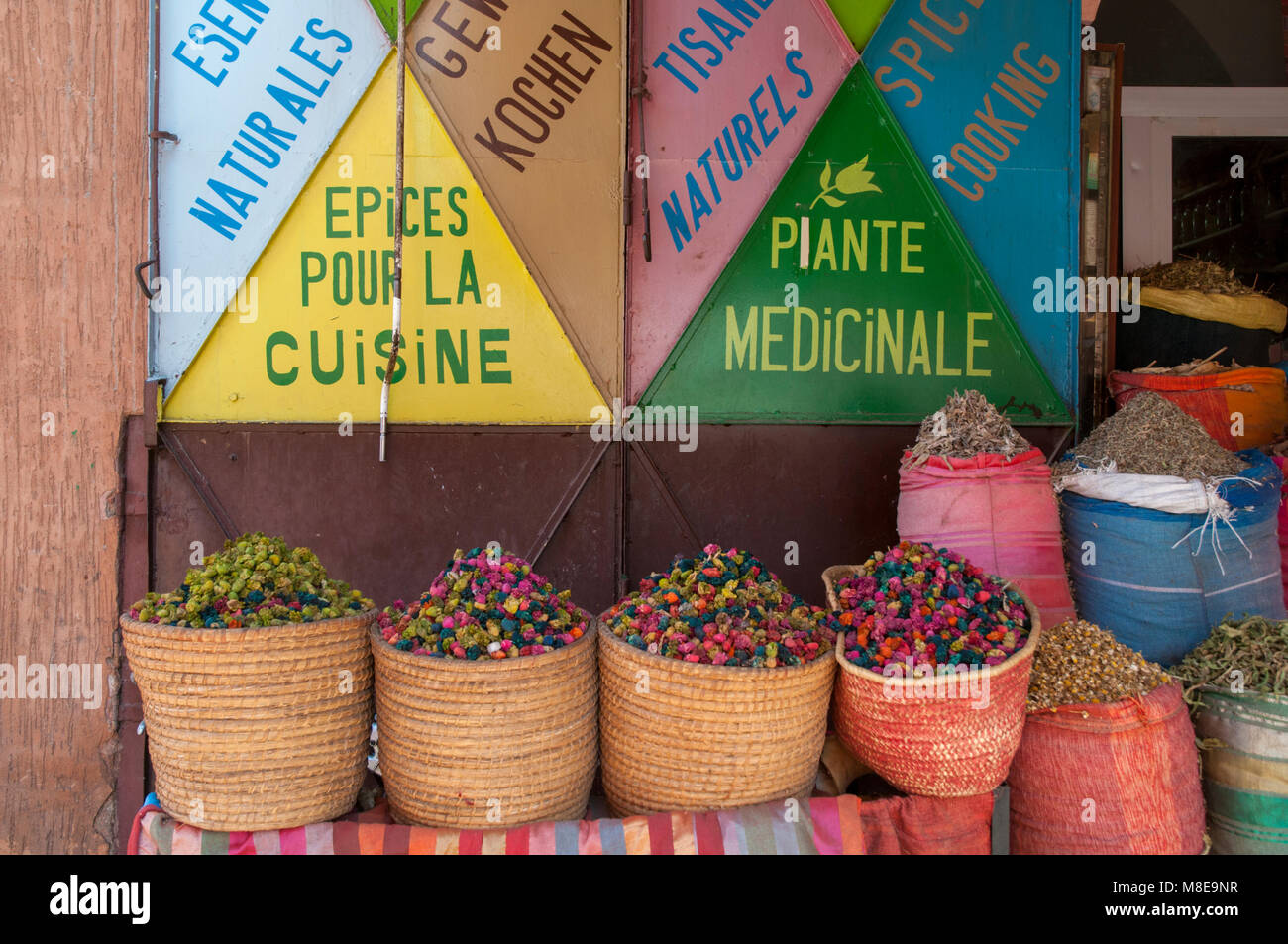 Cestini e sacchi riempiti con ingredienti naturali per cucinare e per scopi medicinali al di fuori di un negozio in un mercato delle spezie di Marrakech, Marocco. Foto Stock