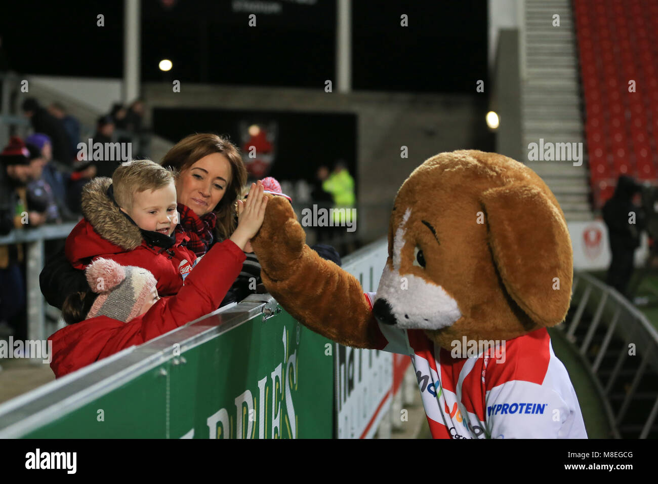 St Helens,Merseyside, Regno Unito. 16 marzo 2018, totalmente Wicked Stadium, St Helens,Merseyside, Inghilterra; Betfred Super League Rugby, Round 6, St Helens versus Leeds rinoceronti; avvia il St Helens mascotte battendo il cinque un giovane fan Credito: News Immagini/Alamy Live News Foto Stock