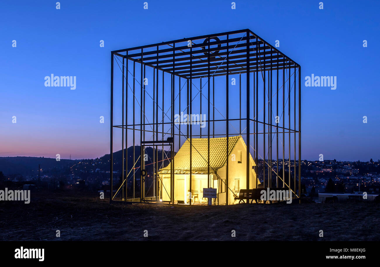 14 marzo 2018, Germania, Pforzheim: il progetto d'arte 'minaccia di casa" (tedesco: "Come bedrohte Haus') nella foto dipinte in giallo, accesa e immerso in alto le barre della gabbia. Il piccolo, svuotare una camera casa è stata trasformata in un arte di installazione per Artista e ingegnere Andreas Sarow. Secondo Sarow se stesso, il suo scopo con questo progetto è quello di richiamare l' attenzione su "le cose nuove che sono prossimi e che cosa si deve rinunciare in Exchange'. Egli critica anche il borghese costruzione design. Foto: Uli Deck/dpa Foto Stock