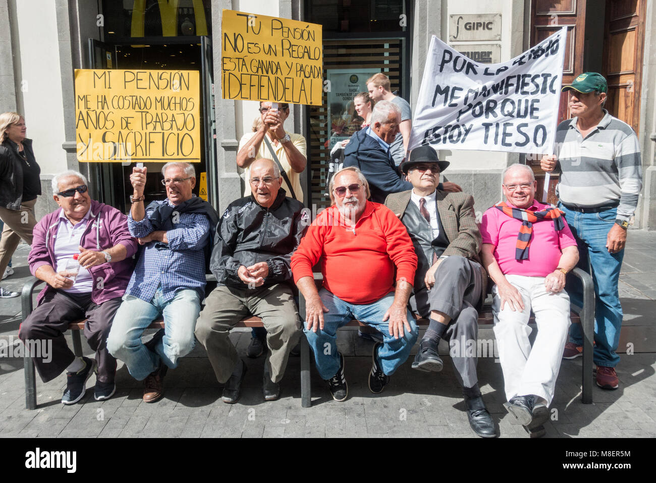 Gran Canaria Isole Canarie Spagna. Il 17 marzo 2018. Migliaia di persone si prendono per le strade di Las Palmas de Gran Canaria - e in tutta la Spagna - a protestare per una pensione decente. Nella foto: i manifestanti seduta su una panchina con cartelli che dicono che ' la mia pensione ha mi è costata anni di duro lavoro e di sacrificio". ' La pensione non è un dono è meritato e pagato. Difenderlo!' Credit: ALAN DAWSON/Alamy Live News Foto Stock