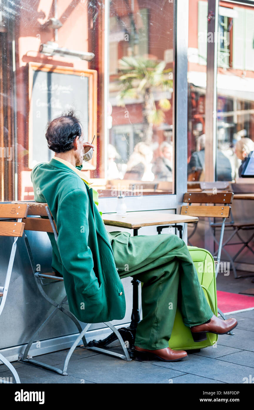 Molto elegante gentleman indossando un recupero verde corrispondente ensemble si rilassa in vecchio stile cafe a Nizza Francia in inverno. Foto Stock