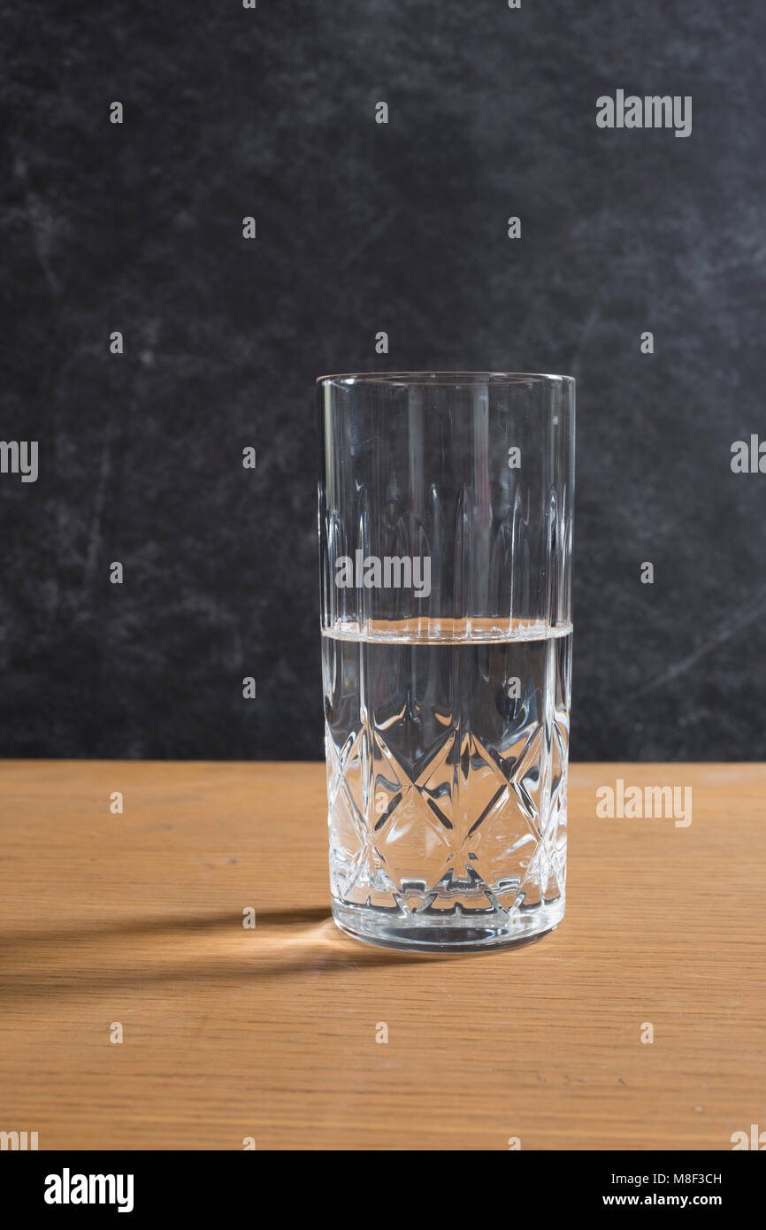 Mezzo bicchiere pieno sul tavolo Foto Stock