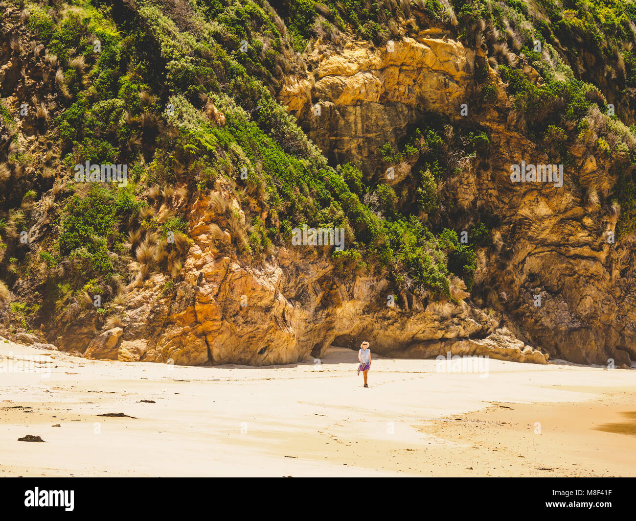 Australia, Nuovo Galles del Sud, Bermagui, Donna camminando lungo la spiaggia Foto Stock